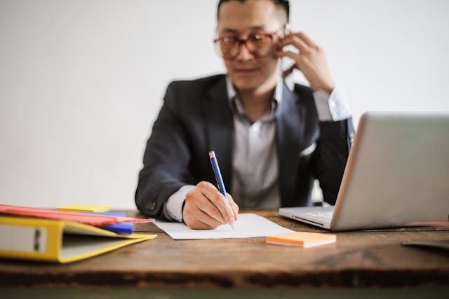 person talking on the phone while writing something done